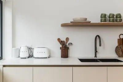 a kitchen counter with white cabinets and a sink at Maison la Bruyere, 8p villa - heated pool, airco & hottub in Franschhoek
