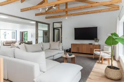 a living room with white furniture and a flat screen tv at Maison la Bruyere, 8p villa - heated pool, airco & hottub in Franschhoek