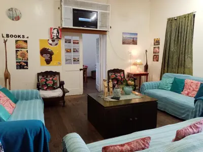 a living room with two couches and a table at Lighthouse Farm Backpackers Lodge in Cape Town