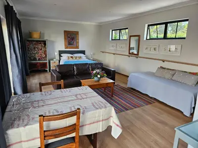 a living room with a bed and a couch at Studio on Main in Hermanus