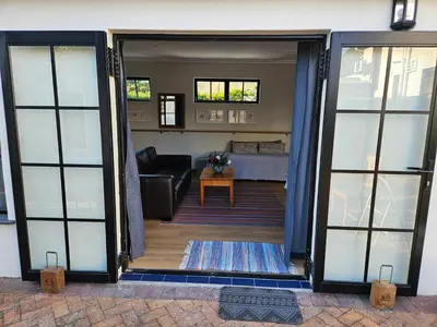 an open door to a living room with a couch at Studio on Main in Hermanus