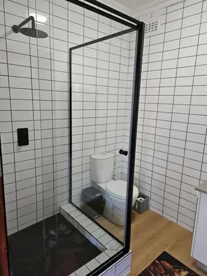 a bathroom with a toilet in a shower stall at Studio on Main in Hermanus