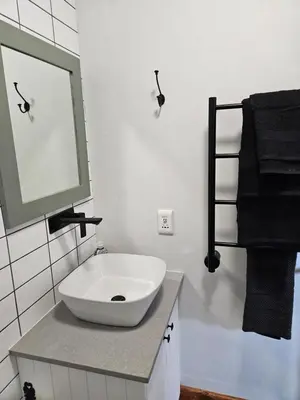 a bathroom with a white sink and a mirror at Studio on Main in Hermanus