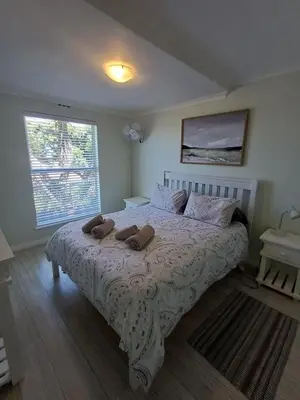 a bedroom with a bed with two pillows on it at 47 Whale Rock Estate in Hermanus