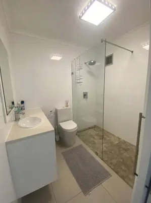 a bathroom with a toilet and a sink and a shower at 47 Whale Rock Estate in Hermanus