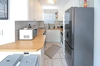 a kitchen with a wooden counter and a refrigerator at Cozy Garden Unit in Bloubergstrand in Bloubergstrand
