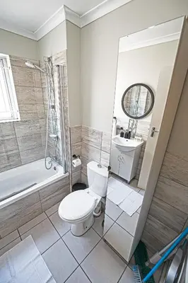 a bathroom with a toilet and a sink and a shower at Cozy Garden Unit in Bloubergstrand in Bloubergstrand