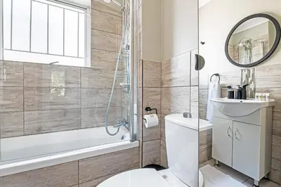 a bathroom with a toilet and a shower and a sink at Cozy Garden Unit in Bloubergstrand in Bloubergstrand