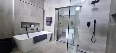 a bathroom with a shower and a white bath tub at Comfort Cove in Cape Town