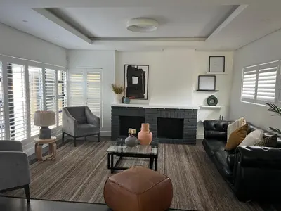 a living room with a couch and a fireplace at Comfort Cove in Cape Town