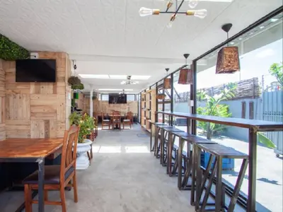 a restaurant with wooden tables and chairs and a television at West Gemini Guesthouse in Cape Town