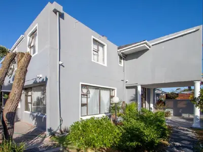 a white house with a street light on it at West Gemini Guesthouse in Cape Town