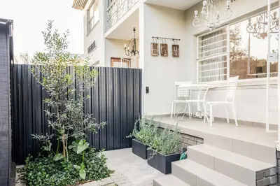 a house with a black fence and some plants at Avemore Vredehof 1 with backup power in Stellenbosch