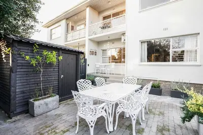 a patio with a white table and chairs at Avemore Vredehof 1 with backup power in Stellenbosch
