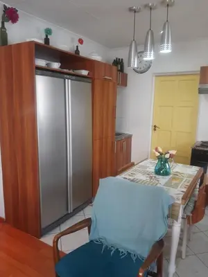 a kitchen with a table and a refrigerator at Local & comfortable in Mandalay