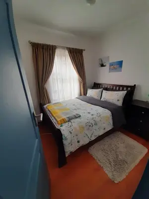 a bedroom with a bed with a window and a rug at Local & comfortable in Mandalay