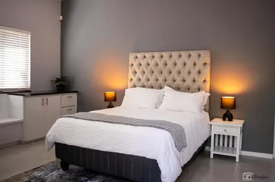 a bedroom with a large bed with two lamps at NamaStay in Cape Town