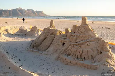 a sand castle on a beach with people in the background at NamaStay in Cape Town