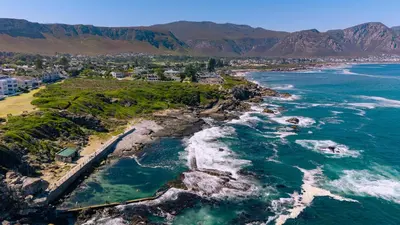 an aerial view of the shoreline of a beach at Seafront Penthouse - Marine Court Hermanus in Hermanus