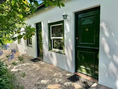 a green door on the side of a building at Keerweder Cottages in Franschhoek