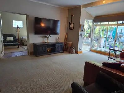 a living room with a large flat screen tv at The Willow Cottage in Cape Town