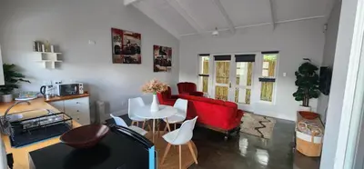 a living room with a red couch and a table at Stellenbosch Paradijs Cottage Paradyskloof in Stellenbosch