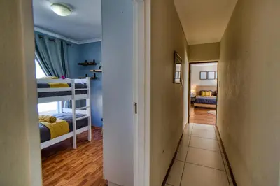 a hallway leading to a bedroom with two bunk beds at Magnificent House in Cape Town