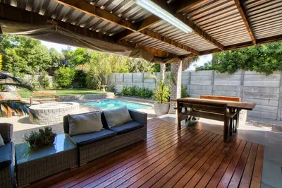 a patio with a couch and a table and a pool at Magnificent House in Cape Town
