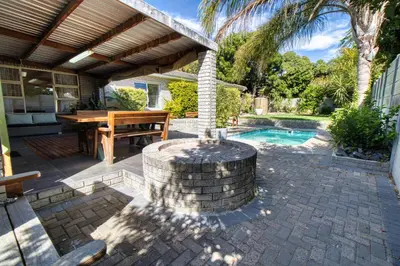 a patio with a table and a swimming pool at Magnificent House in Cape Town