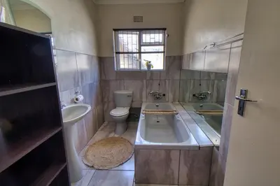 a bathroom with a sink and a toilet and a tub at Magnificent House in Cape Town