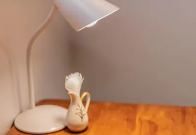 a lamp and a white vase sitting on a table at The Attic - Deluxe Leisure Loft in Stellenbosch