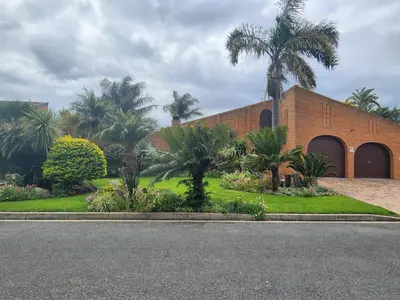 a brick building with palm trees in front of it at Red Door Strand Guest house in Cape Town