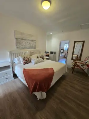 a bedroom with a large bed and a desk at Red Door Strand Guest house in Cape Town
