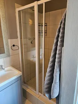 a bathroom with a shower and a sink at SS Luxury Apartments Island Club in Cape Town