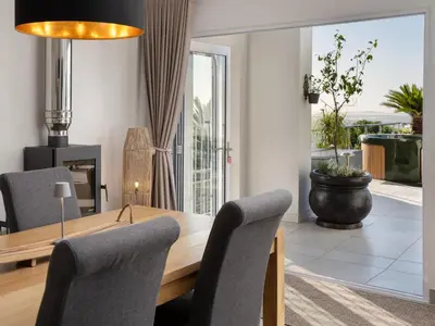 a dining room with a table and chairs at Phezulu Manor, Panoramic Views, Serviced Retreat in Gordonʼs Bay