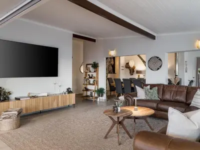 a living room with a couch and a flat screen tv at Phezulu Manor, Panoramic Views, Serviced Retreat in Gordonʼs Bay