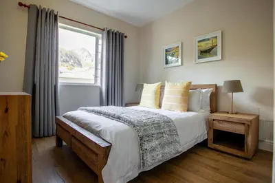 a bedroom with a large bed and a window at Sur La Mer in Hermanus