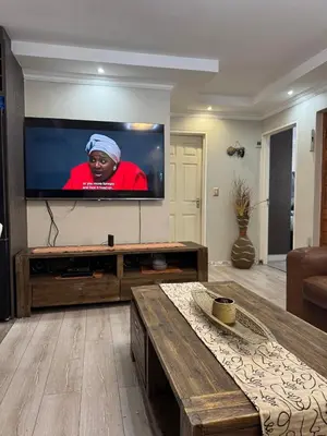 a living room with a large flat screen tv at Self catering three bedroom in Cape Town