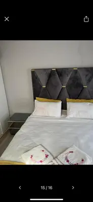 a bed with white sheets and pillows with flowers on it at Self catering three bedroom in Cape Town