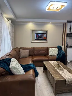 a living room with a brown couch and a coffee table at Self catering three bedroom in Cape Town
