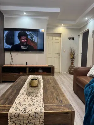 a living room with a large flat screen tv at Self catering three bedroom in Cape Town