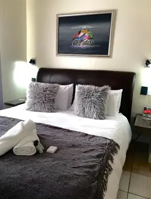 a bedroom with a large bed with a black headboard at The Perfect Cape Town Retreat in Cape Town