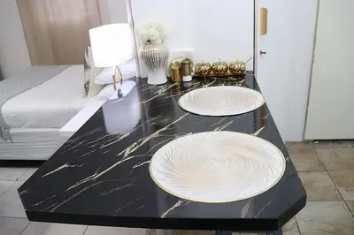 two white plates on a black counter in a room at Optimum Stay Self Catering Accommodation - Deluxe Room in Cape Town