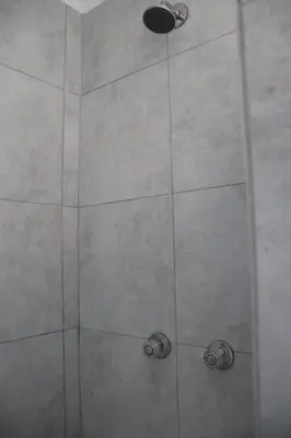 a shower with a glass door with two handles at Optimum Stay Self Catering Accommodation - Deluxe Room in Cape Town