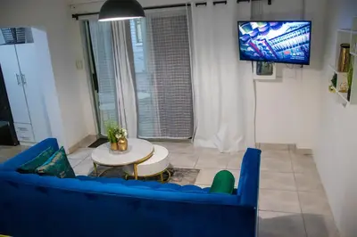 a living room with a blue couch and a table at Optimum Stay Self Catering Accommodation - Deluxe Room in Cape Town