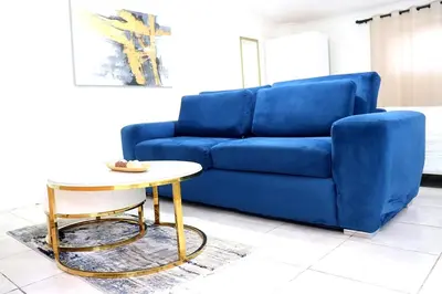 a blue couch and a table in a living room at Optimum Stay Self Catering Accommodation - Deluxe Room in Cape Town