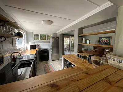a large kitchen with wooden counter tops and stainless steel appliances at Mosselberg Garden Gottage in Hermanus
