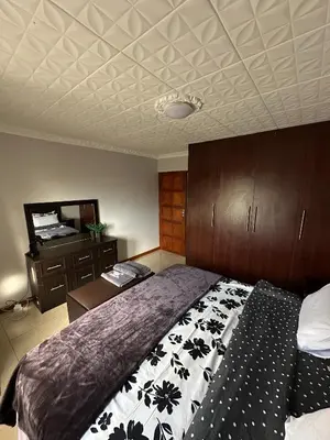 a bedroom with a bed and a table and a ceiling at Luxurious 4 bedroom Family Home in Cape Town