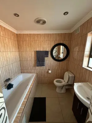 a bathroom with a tub and a toilet and a sink at Luxurious 4 bedroom Family Home in Cape Town