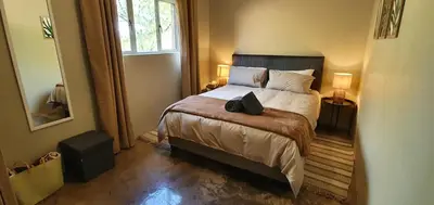 a bedroom with a bed with a bag on it at Riverbank in Tulbagh